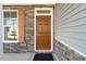 Home features a brown front door with stone accents at 26 Steppe Way, Garner, NC 27529