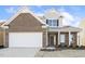 Brick two-story house with a white garage door and landscaping at 36 Steppe Way, Garner, NC 27529
