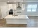 Bright kitchen with a large island, stainless steel appliances, and modern pendant lighting at 428 Fast Pitch Ln, Four Oaks, NC 27524