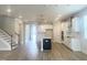Open-concept living room with wood floors flows into the modern kitchen with an island and stainless appliances at 428 Fast Pitch Ln, Four Oaks, NC 27524