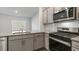 Modern kitchen with gray cabinets, granite countertops, and stainless steel appliances at 168 Perseus St, Angier, NC 27501