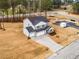 Aerial view showcasing a gray two-story home with a three-car garage and concrete driveway at 7404 Prato Ct, Wendell, NC 27591
