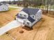 Birds-eye view of a modern two-story home, showcasing its gray exterior, three-car garage, and driveway at 7404 Prato Ct, Wendell, NC 27591