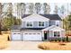 Charming two-story home with gray siding, black roof, and a three-car garage on a concrete driveway at 7404 Prato Ct, Wendell, NC 27591