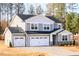 Two-story home with gray siding, black roof, three-car garage, and stone veneer accents at 7404 Prato Ct, Wendell, NC 27591