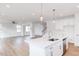 Bright, open kitchen featuring a quartz countertop island with stainless steel appliances and stylish pendant lighting at 7404 Prato Ct, Wendell, NC 27591