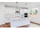 A bright kitchen features white cabinets, quartz countertops, subway tile, stainless steel appliances, and an island at 7404 Prato Ct, Wendell, NC 27591