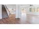 Spacious living room featuring hardwood floors, an open staircase, and large windows at 7404 Prato Ct, Wendell, NC 27591