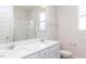 Bright bathroom with double sink vanity, quartz countertops, and glass shower at 398 Fast Pitch Ln, Four Oaks, NC 27524