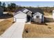New home featuring stone details, white siding, attached garage, and freshly installed landscaping at 472 Barbour Farm Ln, Four Oaks, NC 27524