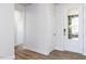 Bright foyer featuring wood-look floors, white walls, and a front door with decorative glass at 472 Barbour Farm Ln, Four Oaks, NC 27524