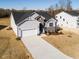 New home showcasing a concrete driveway, stone accents, white trim, and a two-car garage at 472 Barbour Farm Ln, Four Oaks, NC 27524
