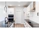 Contemporary kitchen boasting white cabinets, granite countertops, stainless steel appliances, and modern fixtures at 472 Barbour Farm Ln, Four Oaks, NC 27524