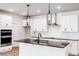 Modern kitchen featuring white cabinets, granite countertops, stainless steel appliances, and stylish lighting at 472 Barbour Farm Ln, Four Oaks, NC 27524