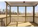 Screened porch with wood flooring and railings, providing an outdoor living space at 472 Barbour Farm Ln, Four Oaks, NC 27524