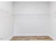 A large walk-in closet with white walls, wood-look floors and plenty of shelving space for storage at 472 Barbour Farm Ln, Four Oaks, NC 27524