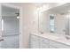 Bathroom with double sinks, white cabinets, and a view into the carpeted bedroom at 576 Barbour Farm Ln, Four Oaks, NC 27524