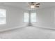 Spacious bedroom featuring neutral walls, plush carpet, and natural light from multiple windows at 576 Barbour Farm Ln, Four Oaks, NC 27524
