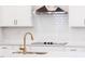 Modern kitchen featuring white cabinets, a white subway tile backsplash, and gold hardware at 576 Barbour Farm Ln, Four Oaks, NC 27524
