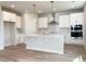 Modern kitchen with white cabinets, stainless steel appliances, an island, and wood-look flooring at 576 Barbour Farm Ln, Four Oaks, NC 27524