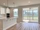 Modern open-concept kitchen with quartz countertops, stainless steel appliances, and access to a screened porch at 576 Barbour Farm Ln, Four Oaks, NC 27524