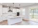 Bright, modern kitchen boasts white cabinets, stainless steel appliances, and a spacious island with a gold faucet at 576 Barbour Farm Ln, Four Oaks, NC 27524