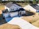 Aerial view of a home with a long driveway and a spacious, well-maintained lawn at 644 Barbour Farm Ln, Four Oaks, NC 27524