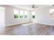 Bright living room featuring wood-look flooring, large windows, and recessed lighting at 644 Barbour Farm Ln, Four Oaks, NC 27524