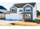 Charming two-story home with gray and white siding, a two-car garage, and a well-manicured lawn at 674 Barbour Farm Ln, Four Oaks, NC 27524