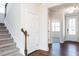 Bright foyer with staircase, white doors, and hardwood flooring, creating a welcoming entrance at 674 Barbour Farm Ln, Four Oaks, NC 27524
