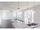 Open concept living area with an island, a view of the backyard, and modern lighting at 674 Barbour Farm Ln, Four Oaks, NC 27524