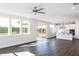 Bright living room with dark wood floors and many windows overlooking the backyard at 674 Barbour Farm Ln, Four Oaks, NC 27524