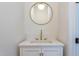 Modern bathroom with white vanity, gold fixtures, and round mirror at 8780 Old Nc 86, Chapel Hill, NC 27516