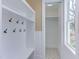 White laundry room with built-in shelving, hooks, and patterned tile floor at 8780 Old Nc 86, Chapel Hill, NC 27516
