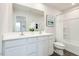 Bright bathroom featuring a dual sink vanity, large mirror, and a shower-tub combination at 1581 Ivy Meadow Ln, Zebulon, NC 27597