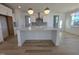 Modern kitchen with white cabinets, large island, and pendant lighting at 1109 Prominence Dr., Homesite 17, Durham, NC 27712