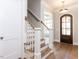 Entryway with wooden floors, a staircase with white banisters, and a view of the front door at 81 Autumn Gate St, Pittsboro, NC 27312