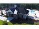 Community pool with a splash fountain, surrounded by lounge chairs, landscaping, and a clubhouse at 7417 Dover Hills Dr, Wake Forest, NC 27587