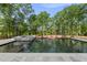 In-ground pool and hot tub with surrounding tile and lush landscaping against a backdrop of trees at 7417 Dover Hills Dr, Wake Forest, NC 27587