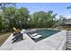 Inviting backyard pool area with stylish lounge chairs and a spa, set against a backdrop of mature trees and blue skies at 7417 Dover Hills Dr, Wake Forest, NC 27587