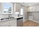 Well-lit kitchen with stainless steel dishwasher, white cabinets, and a view to outside at 98 Linda St, Princeton, NC 27569
