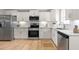 Bright kitchen with white cabinets, stainless appliances, granite counters, and wood floors at 98 Linda St, Princeton, NC 27569
