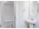 Elegant powder room featuring a pedestal sink, modern fixtures, and a decorative oval mirror at 370 Fast Pitch Ln, Four Oaks, NC 27524