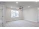 Spacious carpeted bedroom filled with natural light featuring a ceiling fan and neutral walls at 370 Fast Pitch Ln, Four Oaks, NC 27524