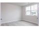 Minimalist bedroom with new hard wood style flooring, a large window, and freshly painted white walls at 370 Fast Pitch Ln, Four Oaks, NC 27524
