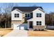 Charming two-story home featuring a two-car garage, stone accents, and a well-manicured lawn at 370 Fast Pitch Ln, Four Oaks, NC 27524