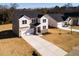 Aerial view of a two-story home showcasing a stone facade, attached garage, and concrete driveway at 370 Fast Pitch Ln, Four Oaks, NC 27524