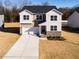 Two-story home with stone facade, garage, concrete driveway, and landscaped front yard at 370 Fast Pitch Ln, Four Oaks, NC 27524