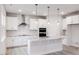 Bright, modern kitchen with stainless steel appliances, a large island, and stylish pendant lighting at 370 Fast Pitch Ln, Four Oaks, NC 27524