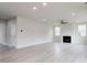 Inviting living area with a cozy fireplace, ceiling fan and plenty of natural light from the large windows at 370 Fast Pitch Ln, Four Oaks, NC 27524